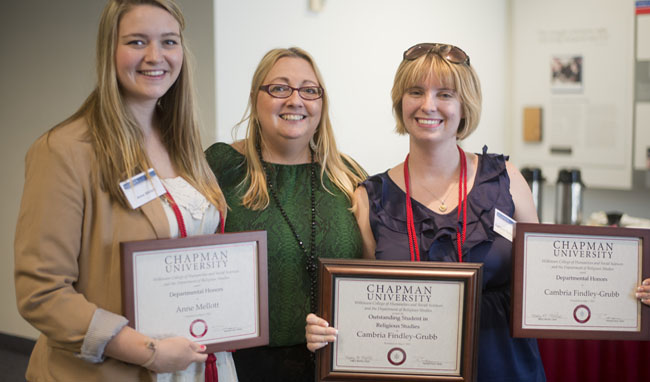 Three women posing with awards.