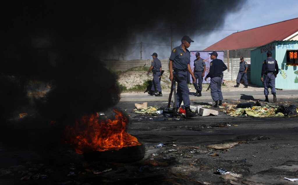 Police behind burning barricades.