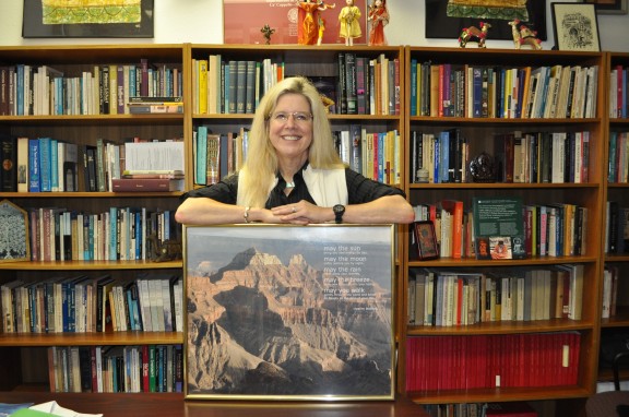 Woman standing with framed photo.