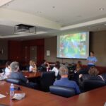 Person giving presentation in front of room of people.
