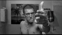 Shirtless man pointing.