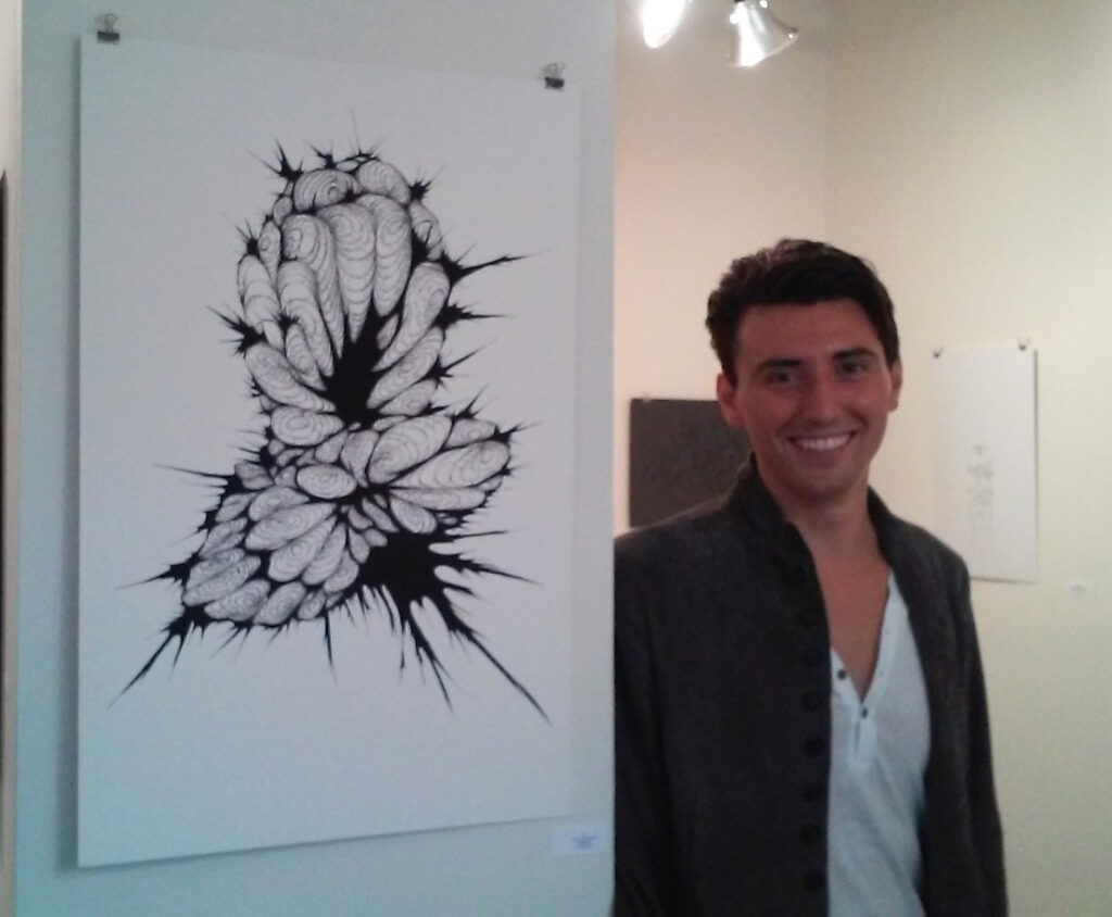 Man smiling next to art.