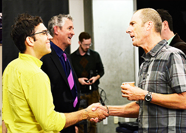 Two men shake hands.