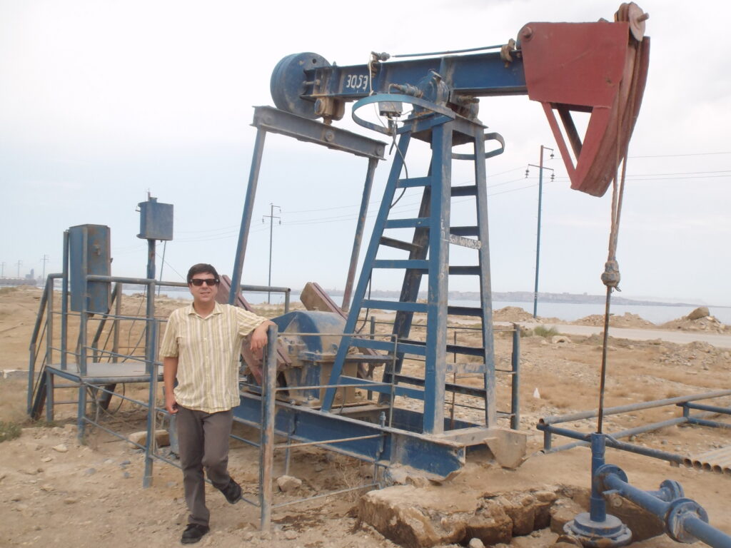 Man standing next to oil well.