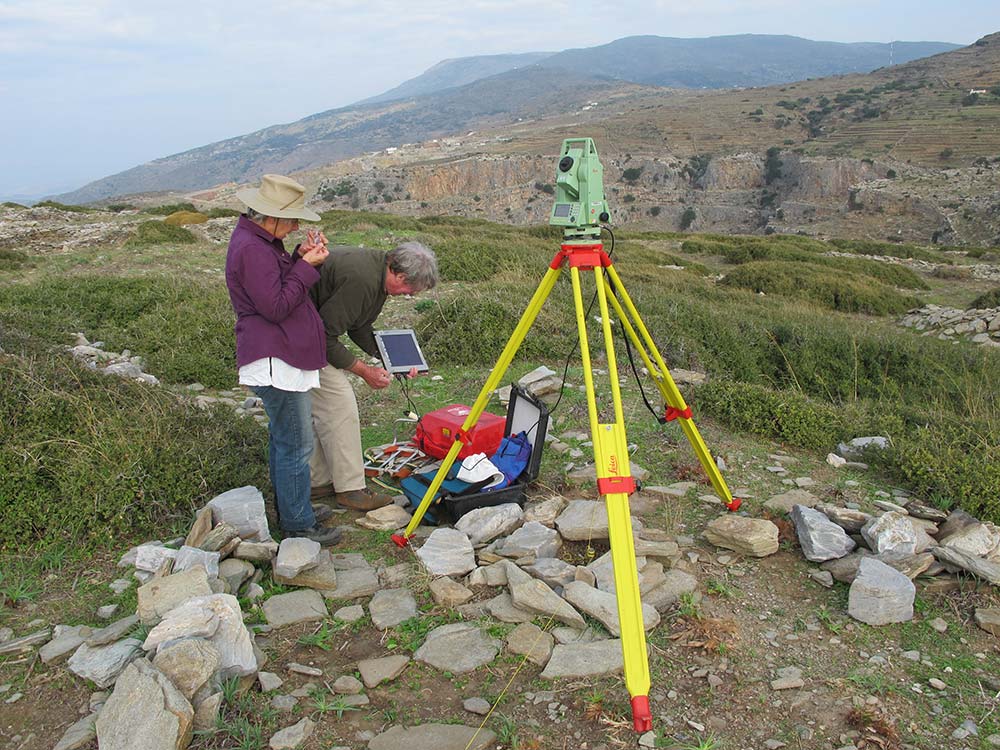 Two people conducting survey of land.