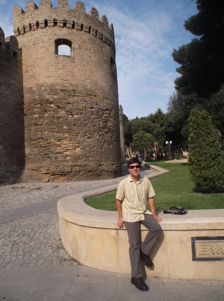 Man smiling next to old city wall.