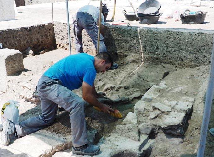 Two people helping with archaeological dig.