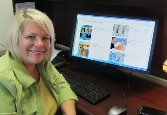Woman smiling next to computer.