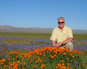 Huell Howser in a field of orange poppies