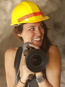 young woman wearing a hard hat and holding a megaphone, smiling