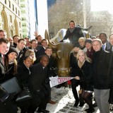 Argyros students and Dean by bull statue on Wall Street