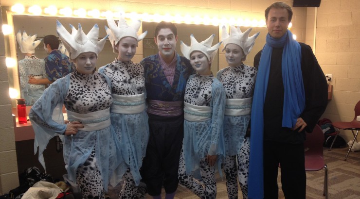 Students pose backstage in costumes at festival.
