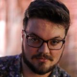 Young man with beard and glasses.