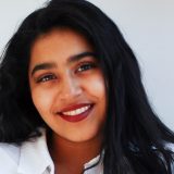 Young woman with long dark hair smiling.