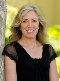 smiling woman with long blonde hair in black blouse