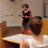 Woman reading from paper for presentation.