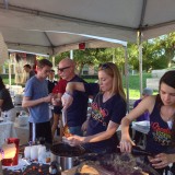 People participating in stew and brew booth.