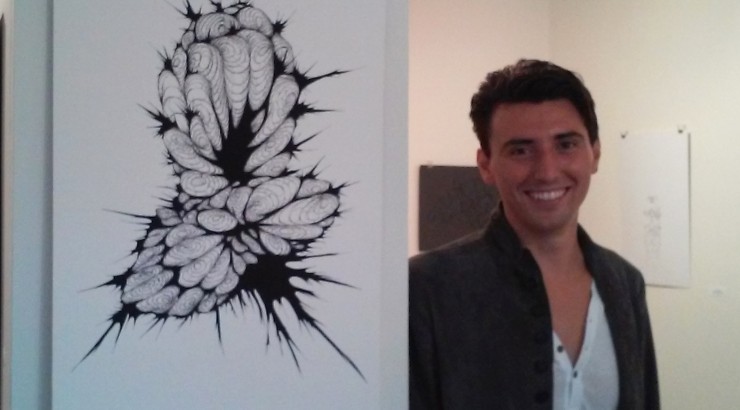 Man smiling next to art.