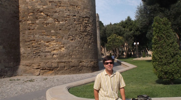 Man smiling next to old city wall.
