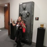 Digital Arts student poses in front of replica of frozen Han Solo