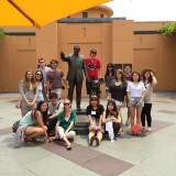 Image of Chapman Students posing with the Walt Disney statue outside of Disney Studios