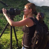 student framing camera in tropical landscape