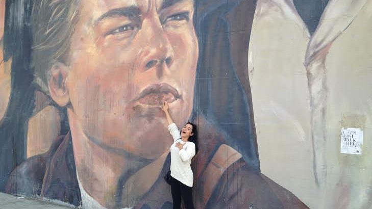 Yashar in front of a mural