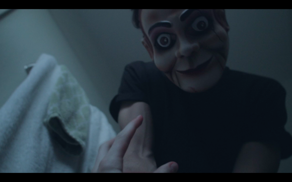 ventriloquist's dummy looking at a person in bed