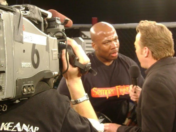 man being interviewed with a cameraman standing beside him