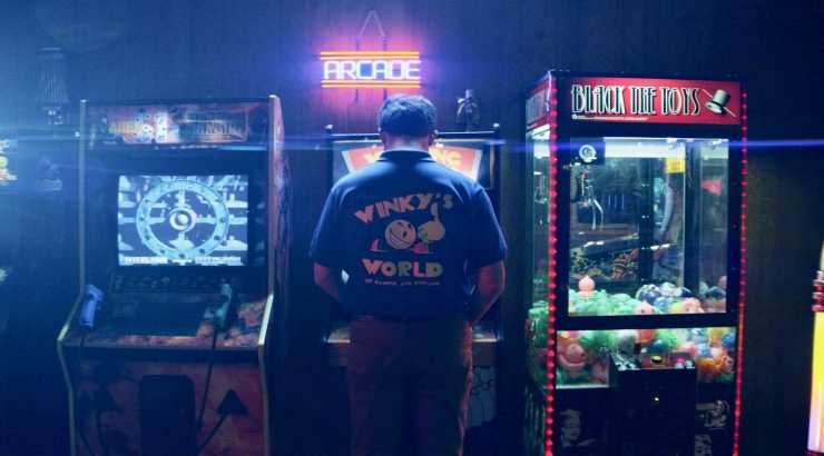 Man playing arcade game, seen from behind