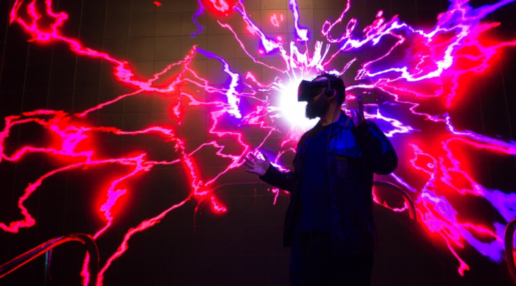 Jon Schnitzer pictured in a VR experience of neon pink electricity waves