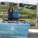 Two women pose in support of autism awareness.
