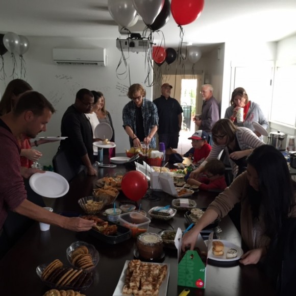 Group of people serving themselves at a potluck.