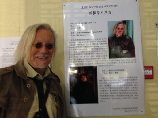 Peter McLaren poses next to poster at International Conference on Critical Pedagogy