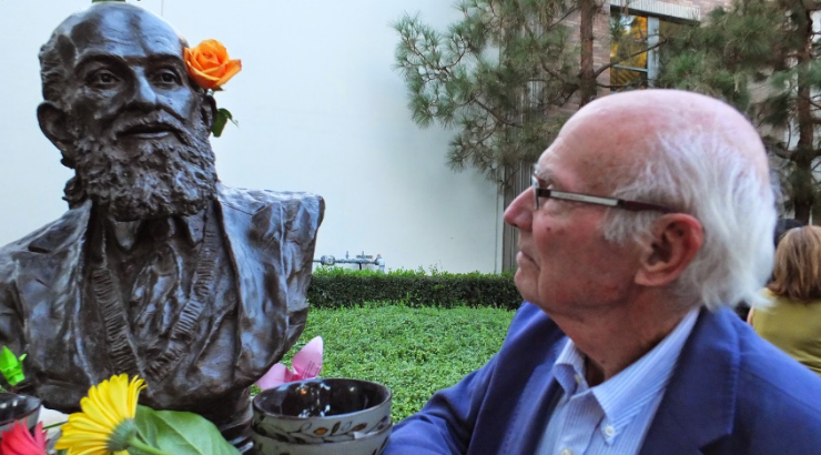 Tom Wilson standing next to Chapman bust of Paulo Freire