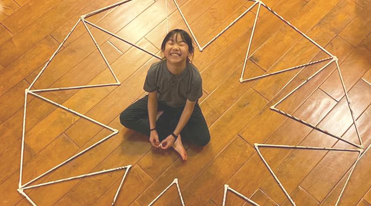 Child on the floor with homemade math structure