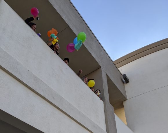 Students throwing eggs in baskets off a second floor