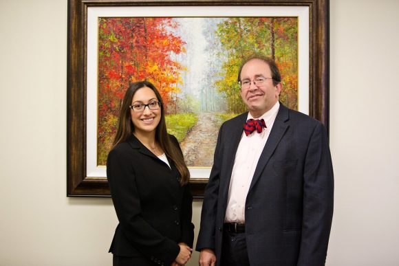 People smiling in front of painting