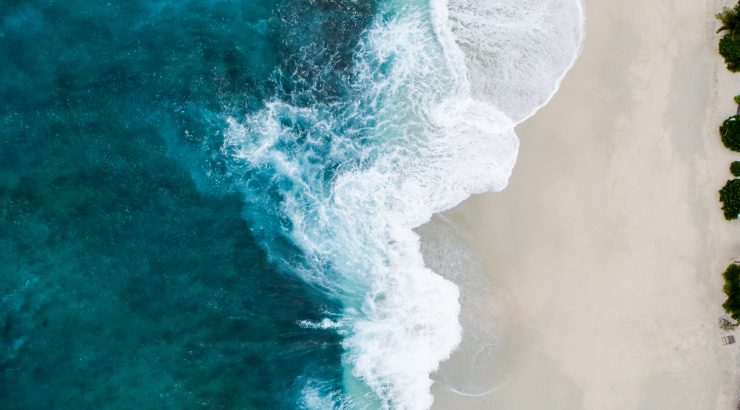 blue ocean waves curling on a sandy beach
