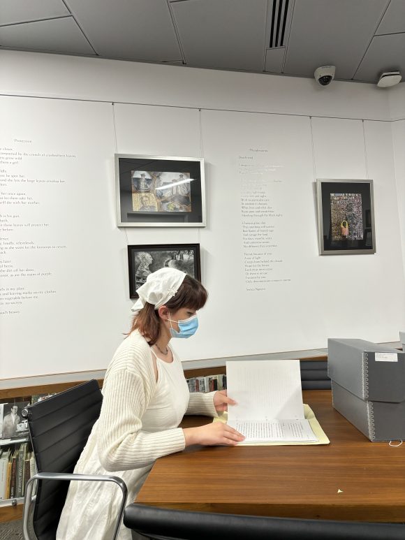 Student looking at document, an archival box is on the table