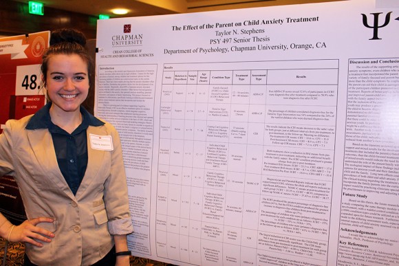 Student stands with research board