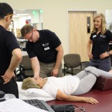Members of the Department of Physical Therapy stretch out a patient.