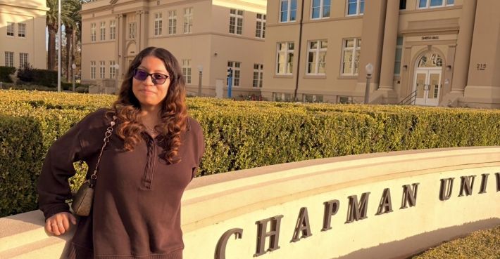 Briana Sitting on the Chapman Sign
