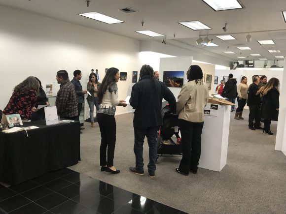 Photograph of a crowd of people viewing an art exhibit