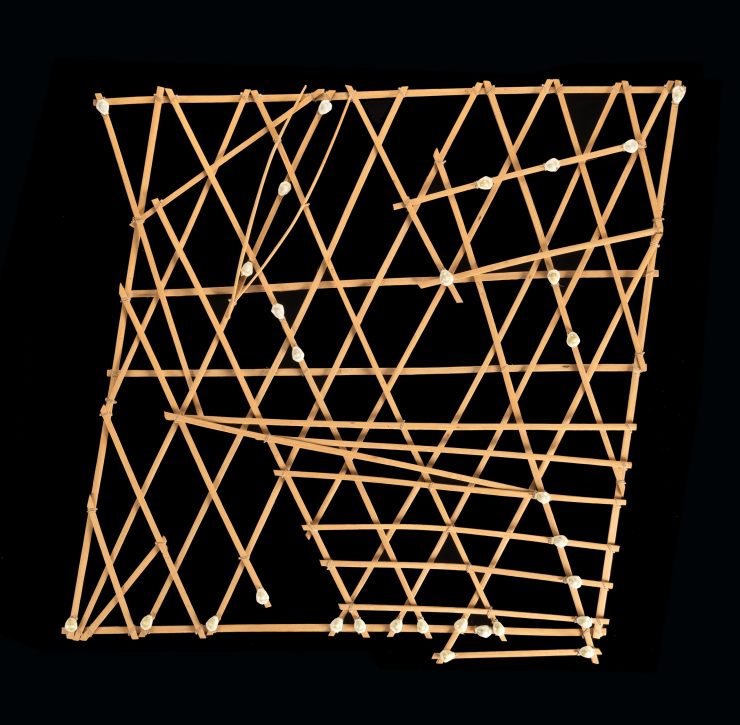Photograph of a stick chart, made of small pieces of wood, on a black background