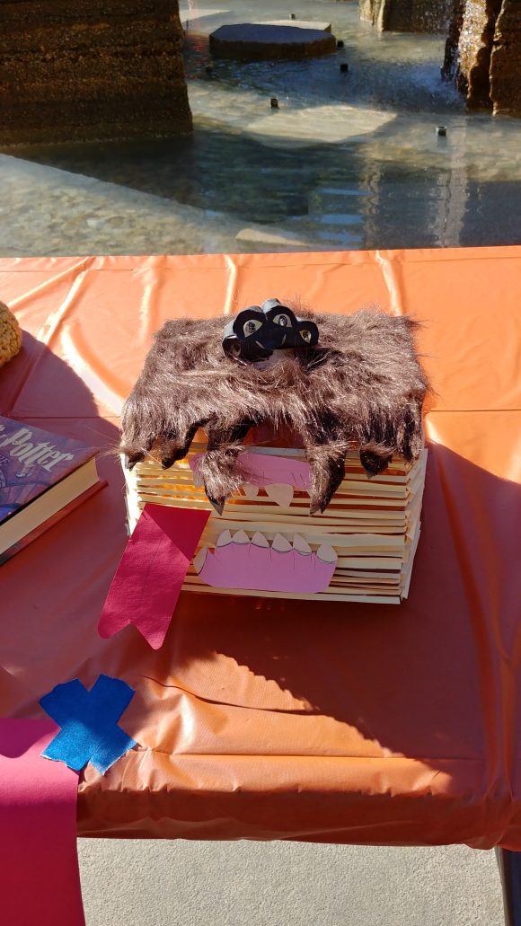 A plastic pumpkin decorated as the Monster Book of Monsters, using paper and fake fur
