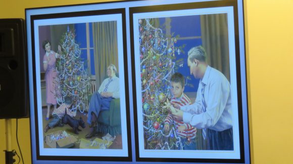A projector screen showing two side-by-side illustrations of a family decorating a Christmas tree