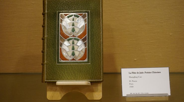 Close-up of a book with a detailed green cover with inlaid mother-of-pearl designs