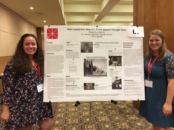 Blaise and Saul presenting research poster titled "Nazi Looted Art. View of a Dutch Square Through Time."