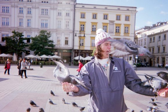 Student with pigeons in a plaza
